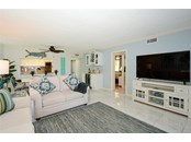 Living room to dining with dry bar and wine refrigerator.  Bedroom 2 visible through hallway. Pocket door for privacy - Condo for sale at 450 Gulf Of Mexico Dr #B107, Longboat Key, FL 34228 - MLS Number is A4520786