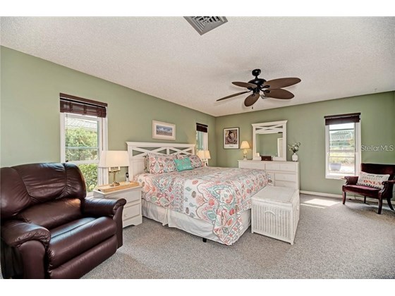 large master bedroom with walk in closet and ensuite plus a slider to the lanai - Single Family Home for sale at 10 Pine Ridge Way, Englewood, FL 34223 - MLS Number is N6118641